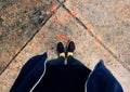 Woman feet in black clothes stand with orange petals fall in raining day