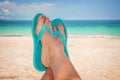 Woman feet with blue flip flops, beach and sea Royalty Free Stock Photo