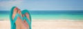 Woman feet with blue flip flops, beach and sea in the background, travel concept