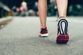 Woman feet close-up wearing sneakers during marathon run on asphalt city road