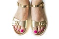 Woman feet in gold sandals onthe white background.