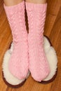 Woman feet in knitted woolen socks standing on fluffy slippers Royalty Free Stock Photo