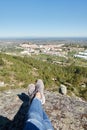 Woman feet at nature landscape in Serra de Sao Mamede mountains with Castelo de Vide city on the background on a sunny day, in Royalty Free Stock Photo