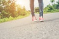 Woman feet with red sneaker shoes walking on the roadside. Royalty Free Stock Photo