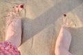 Woman feet on the sand near the sea. Feet girl on the beach in the water, close-up. A woman stands near the sea Royalty Free Stock Photo