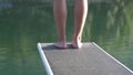 Woman feet on springboard in front of a lake