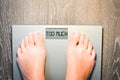 Woman feet stepping on a weight scale having problems with her diet