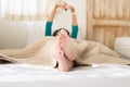 Woman with feet and stretch lazily on white bed after waking up in the morning,Close up of barefoot Royalty Free Stock Photo