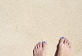 Woman feet on white beach sand. White sand top view photo for background. Royalty Free Stock Photo
