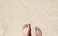 Woman feet on white sand beach. Relaxed barefoot woman by sea.