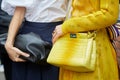 Woman with Fendi yellow reptile leather bag before Fendi fashion show, Milan Fashion Week