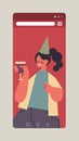 Woman in festive hat celebrating online birthday party happy girl in smartphone screen drinking wine