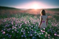 Woman in field of flowers at sunset
