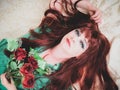 Woman with fiery red hair close up. Lying down.