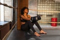 Woman fighter girl power. African american woman fighter with boxing gloves sitting on boxing ring waiting and resting Royalty Free Stock Photo