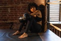 Woman fighter girl power. African american woman fighter with boxing gloves sitting on boxing ring waiting and resting Royalty Free Stock Photo