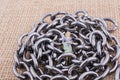Woman figurine on steel chains on a textured surface