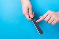 Woman filing her nails on a blue background. Royalty Free Stock Photo