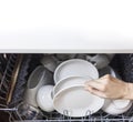 Woman fill the used dish in dishwasher machine in kitchen at home.Hand of female holding the dish.