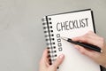 Woman filling Checklist at light grey table, top view. Space for text Royalty Free Stock Photo