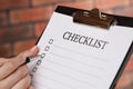 Woman filling Checklist with pen, closeup view