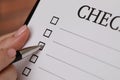 Woman filling Checklist with pen, closeup view