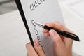 Woman filling Checklist with pen at table, closeup view Royalty Free Stock Photo