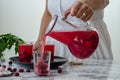 Woman is filling cranberry juice in glass. Royalty Free Stock Photo