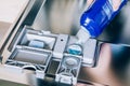 Woman filling dishwasher with gloss liquid. Dishwasher machine