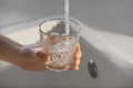 Woman filling glass with tap water from faucet in kitchen, closeup Royalty Free Stock Photo