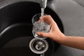 Woman filling glass with water from faucet Royalty Free Stock Photo