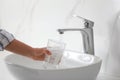 Woman filling glass with water from faucet over sink, closeup Royalty Free Stock Photo