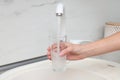 Woman filling glass with water from faucet Royalty Free Stock Photo