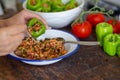 Woman is filling green pepper