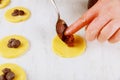 Woman filling homemade cookies with jam