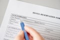 Woman filling hotel reservation form putting first name. Reception desk. Hotel service, registration. Close up. Selective focus.