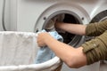 Woman filling laundry in the washing machine, housewife and hygienic