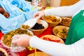 Woman filling meze starters in container