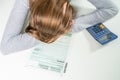 A woman filling out an income tax return and being exhausted