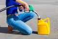 Woman filling yellow can with gasoline or petrol Royalty Free Stock Photo