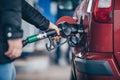 Woman fills petrol into her car at a gas station Royalty Free Stock Photo