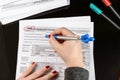 Woman fills the tax form, working with tax documents. Form 1040 Individual Income Tax return form. United States Tax forms.