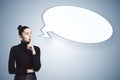 A woman with a finger on her lips and an empty speech bubble on a light background, depicting the concept of silence Royalty Free Stock Photo