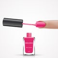 Woman finger with pink nail lacquer brush and bottle