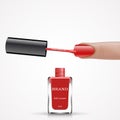 Woman finger with red nail lacquer brush and bottle