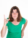 Woman with finger up and angry Head shot Portrait middle aged female in green shirt over white background Royalty Free Stock Photo