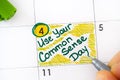 Woman fingers with green pen writing reminder Use Your Common Sense Day in calendar