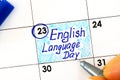 Woman fingers with pen writing reminder English Language Day in calendar