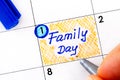 Woman fingers with pen writing reminder Family Day in calendar