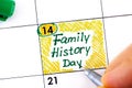 Woman fingers with pen writing reminder Family History Day in calendar